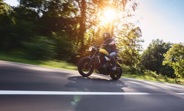 Orman yolunda modern motorsiklet yarışları. Motosiklet turunda boş bir yolda araba sürerken eğleniyorum. bireysel metniniz için kopyalama alanı.
