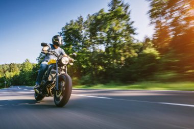 Orman yolunda modern motorsiklet yarışları. Motosiklet turunda boş bir yolda araba sürerken eğleniyorum. bireysel metniniz için kopyalama alanı.