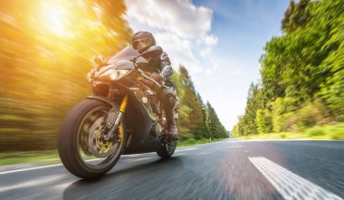 Orman yolunda motosiklet sürerken. Motosiklet turunda boş bir yolda araba sürerken eğleniyorum. bireysel metniniz için kopyalama alanı.
