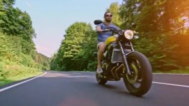 Modern özel scrambler motosiklet sürme - sollama ve eylemleri oyma bir orman yolu üzerinde. Bir motosiklet Tur yolculuğa boş yol sürüş eğleniyor. 4k Video.