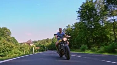 Modern özel scrambler motosiklet sürme - sollama ve eylemleri oyma bir orman yolu üzerinde. Bir motosiklet Tur yolculuğa boş yol sürüş eğleniyor. 4k Video.