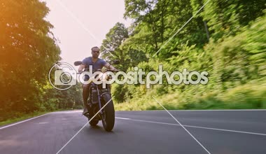 Modern özel scrambler motosiklet sürme - sollama ve eylemleri oyma bir orman yolu üzerinde. Bir motosiklet Tur yolculuğa boş yol sürüş eğleniyor. 4k Video.