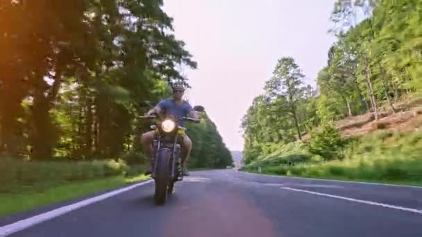现代定制扰摩托车在森林公路骑马超车和雕刻动作 在摩托车旅行的路上开着一条空旷的路很开心 — 图库视频影像