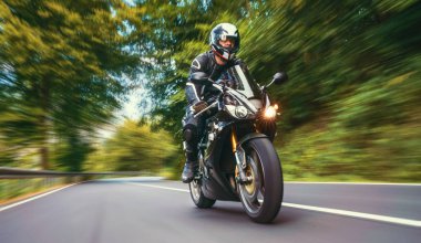 Orman yolunda motosiklet sürerken. Motosiklet turunda boş bir yolda araba sürerken eğleniyorum. bireysel metniniz için kopyalama alanı.