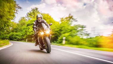 Orman yolunda motosiklet sürerken. Motosiklet turunda boş bir yolda araba sürerken eğleniyorum. bireysel metniniz için kopyalama alanı.