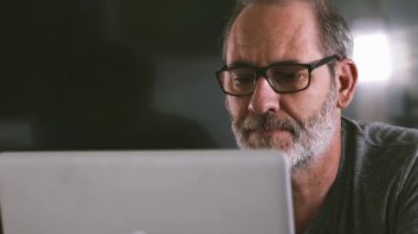 Geceleri şık yaratıcı tasarımcı ofis ahşap masaüstünde dizüstü bilgisayar kullanan geçici iş adamı