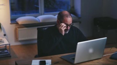 Geceleri şık yaratıcı tasarımcı ofis ahşap masaüstünde dizüstü bilgisayar kullanan geçici iş adamı