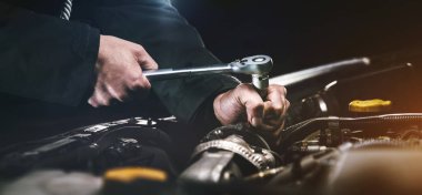 Auto mechanic working on car engine in mechanics garage. Repair service. Authentic close-up shot clipart