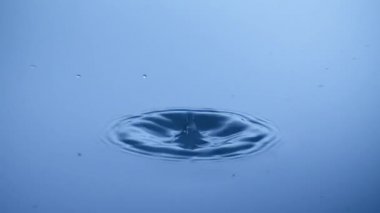 Su damlası sakin yüzey vurur. Fiziksel olarak ağır çekimde çalışma molekülleri gör