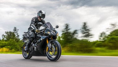 Motosiklet sürerken. Motosiklet turunda boş bir yolda araba sürerken eğleniyorum. bireysel metniniz için kopyalama alanı.