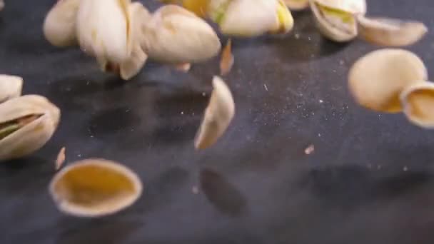 Pimpernoten (pistaches) rollen in super slow motion op zwarte ondergrond — Stockvideo