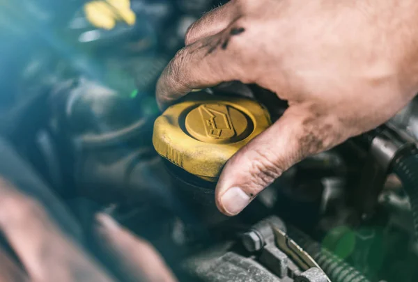 Auto mechanic working on car engine in mechanics garage. Repair service. authentic close-up shot