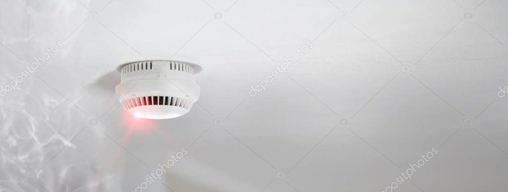 Smoke detector alert mounted on roof in apartment