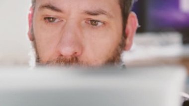 İşadamı ofisinde dizüstü bilgisayarla çalışıyor, veri medya içeriğini düşünüyor, okuyor ve analiz ediyor.