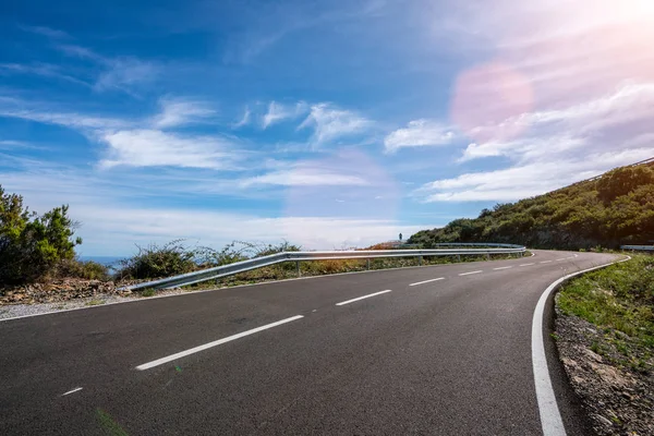 Camino largo vacío de la montaña al horizonte en un día soleado del verano en —  Fotos de Stock