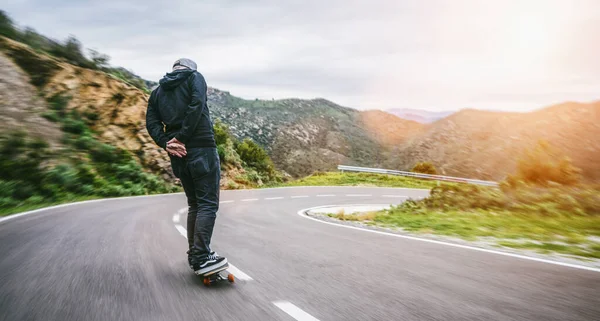 Visão Traseira Homem Montando Skate Estrada Asfalto Montanha Curvilínea — Fotografia de Stock