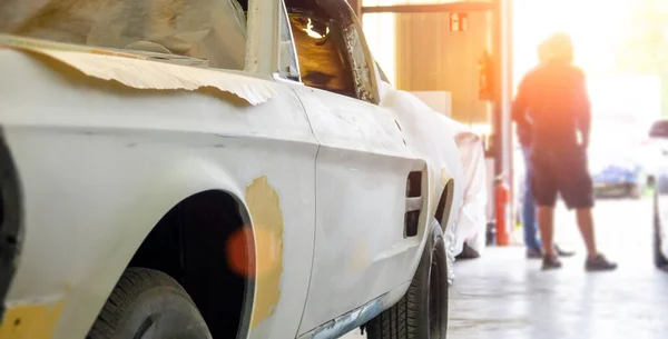 Auto mechanic working on car paint sanding in mechanics garage. workshop repair service. authentic close-up shot