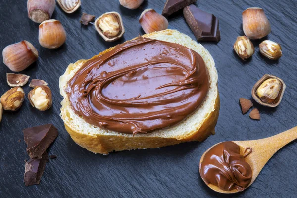 Slice Bread Spread Chocolate Cream Hazelnuts Black Table Serving Delicious — Stock Photo, Image