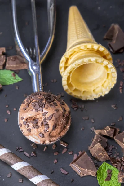 巧克力冰淇淋在独家与晶片棒 锥和巧克力在黑色石板板 重点放在铲冰淇淋 — 图库照片
