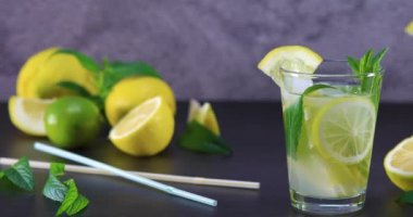 Gri ve siyah arka planda bir cam nane ile ev yapımı ferahlatıcı yaz limonata. Dolly 4k vurdu