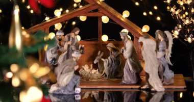 Noel ağacıyakınında atmosferik ışıklar ile İsa Mesih Nativity sahne. Noel sahnesi. Dolly 4k atış