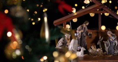 Noel ağacıyakınında atmosferik ışıklar ile İsa Mesih Nativity sahne. Noel sahnesi. Dolly 4k atış