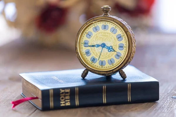 Alter Wecker Auf Der Heiligen Bibel Mit Blumen Auf Holztischhintergrund — Stockfoto