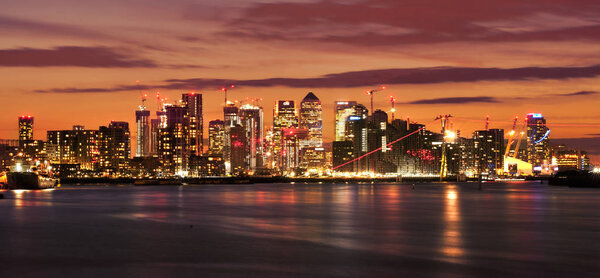 Canary Wharf at night. Illuminated financial district skyline in
