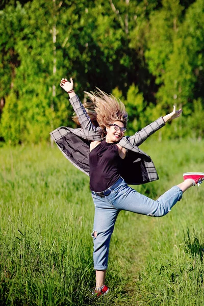 Genç ve güzel Asyalı kız ormanda eğleniyor ve zıplıyor.