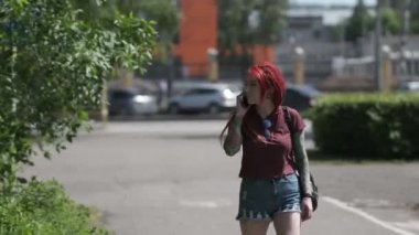  kırmızı saçlı güzel kız ve dreadlocks ve dövme parkta yürüyor