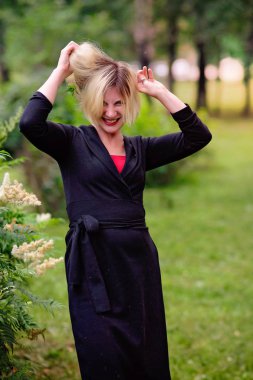 siyah bir elbise bir yaz parkında yürüyor genç kız