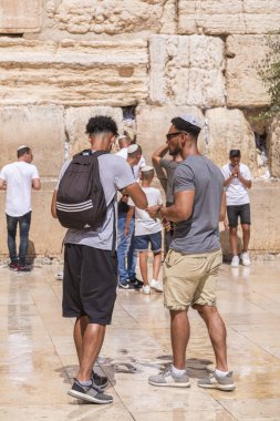 Jerusalem, Israel - June 14, 2018: Jewish people praying against the Western Wall, the second holiest place to the Jews. The Wall is the last remnant of the second temple of Jews in Jerusalem. clipart