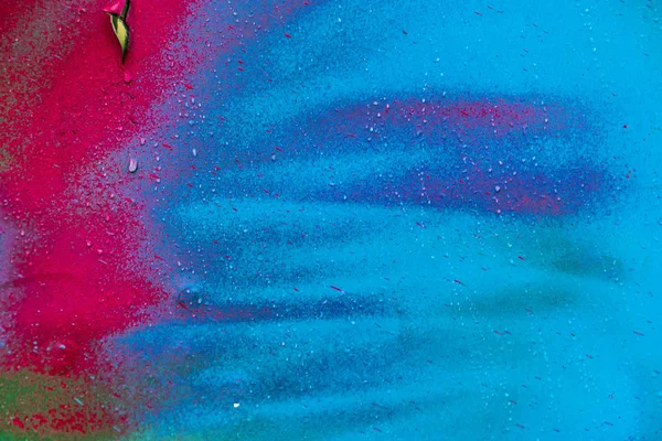 Colorful spray paint splatters on the wall, detailed close up texture background