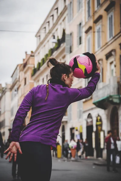 Junge Straßenkünstlerin, die mit ihrem Fußball in — Stockfoto