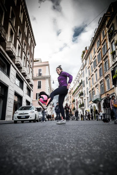 Young female street entertainer performing with her football in — Stock Photo, Image