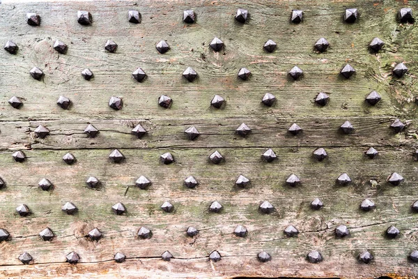 Dettaglio da vecchia porta in legno con rivetti antichi in metallo — Foto Stock