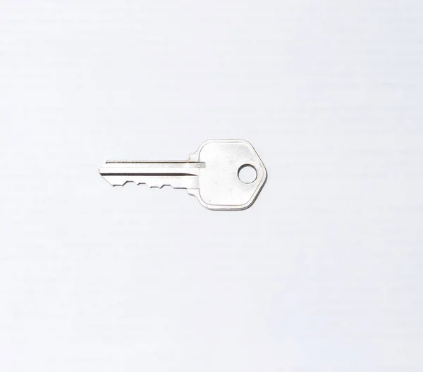 Ένα Μέταλλο Επίπεδη Κλειδί Απομονώνονται Λευκό Φόντο — Φωτογραφία Αρχείου