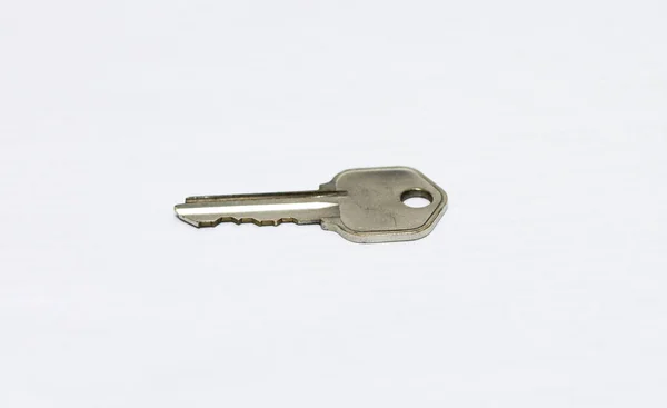 Ένα Μέταλλο Επίπεδη Κλειδί Απομονώνονται Λευκό Φόντο — Φωτογραφία Αρχείου