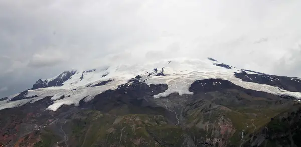 Caucasus mountains under snow and heavy clouds summertime. North Caucasus landscape in august mounth, Russian Federation