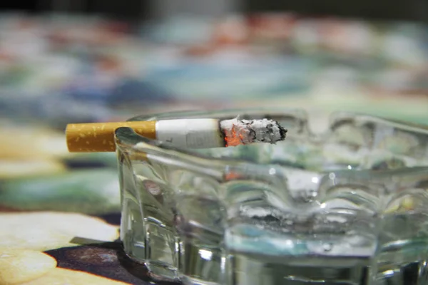 Cinzeiro Vidro Com Cigarro Ardente Quase Fumando Mesa — Fotografia de Stock