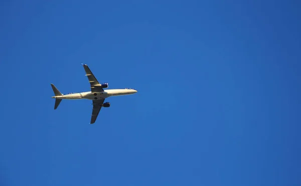 飞机飞向蓝天 晴朗的蓝天背景和飞行机器 Foregroun 图库图片