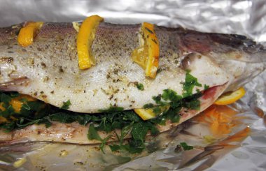 Portakallı, otlu ve baharatlı alabalık ve folyoyla pişirmeye hazır.