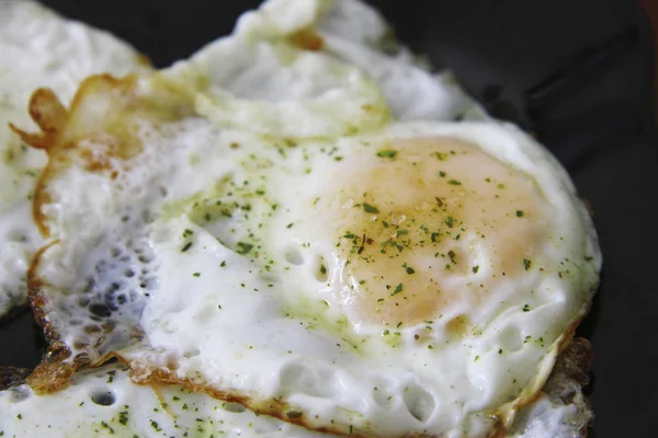 Huevos asados en el plato negro y especias — Foto de Stock
