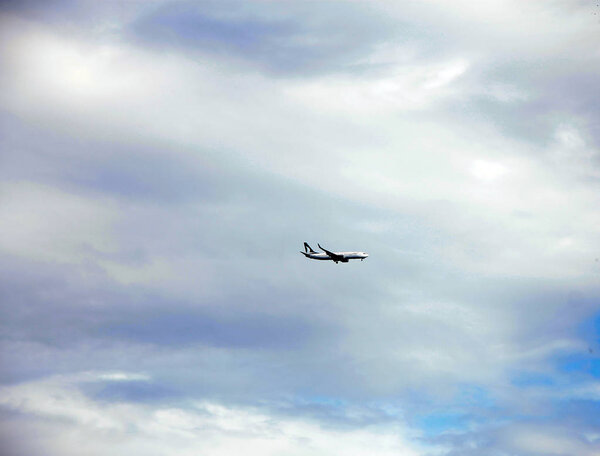 Airplane flying against blue sky. Blue sky with clouds background and flying machine foreground