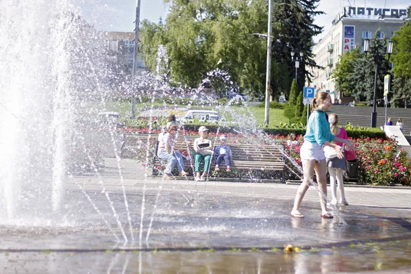 Children near a splashing fontain in the center of town 12 June — Stock Photo, Image