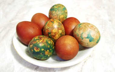 Beyaz tabakta yığın tarafından yerleştirilen renkli Paskalya yortusu yumurta