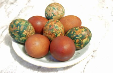 Beyaz tabakta yığın tarafından yerleştirilen renkli Paskalya yortusu yumurta