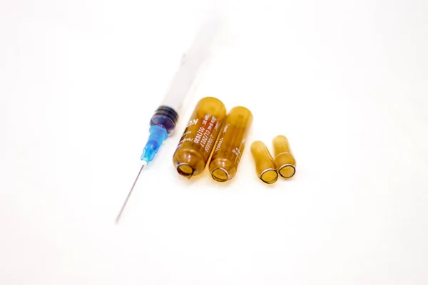 Empty medical ampoules infusion and used syringe after injection — Stock Photo, Image