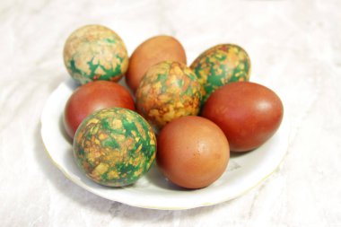 Beyaz tabakta yığın tarafından yerleştirilen renkli Paskalya yortusu yumurta