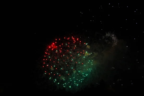 Viering vuurwerk in de zwarte nachtelijke hemel — Stockfoto